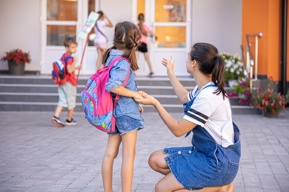 Mom morally supports the daughter holding hands, accompanies student to school.